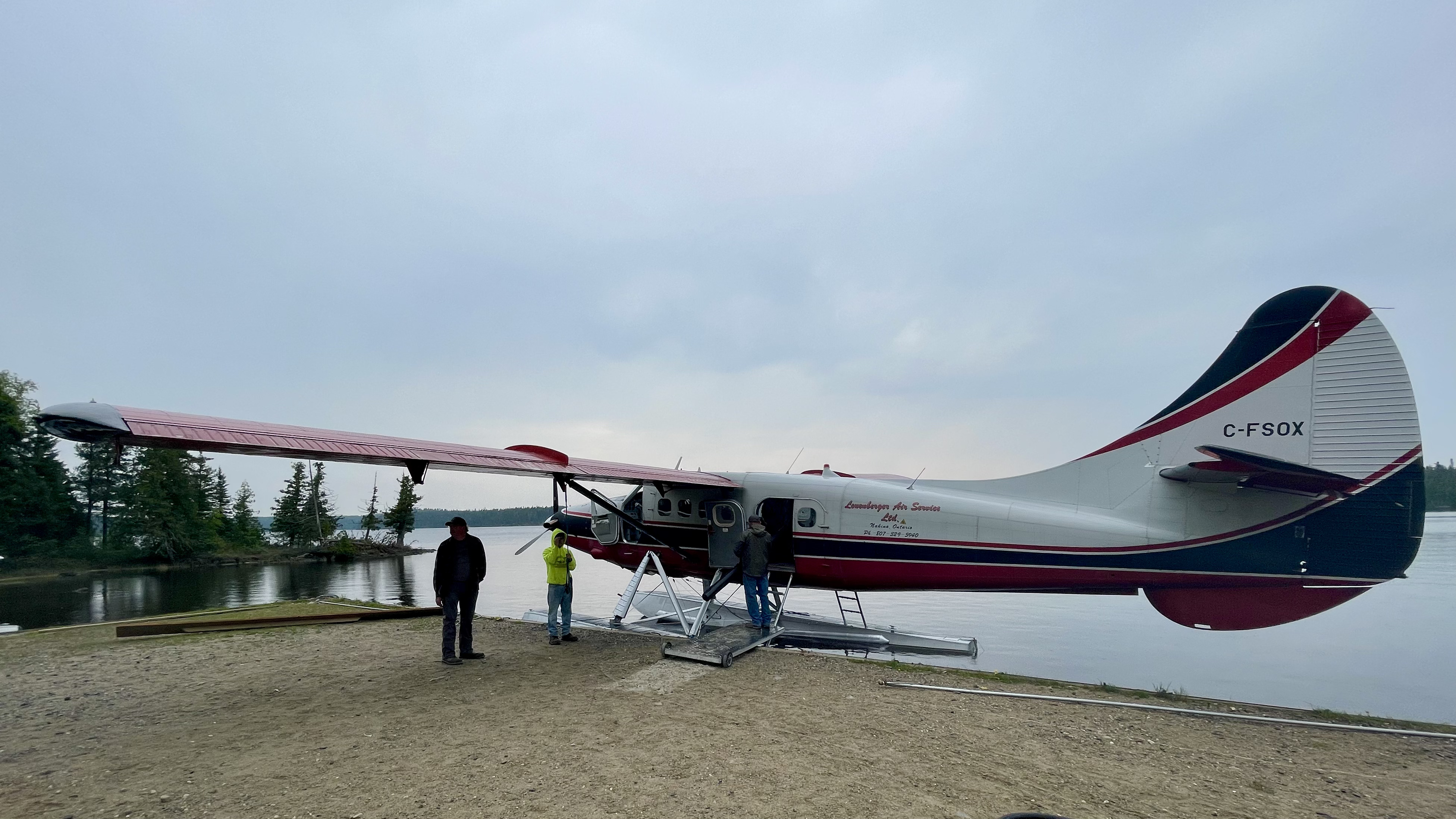 A red and white de Havilland Otter floatplane being loaded at the Leuenberger air base.