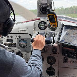 A pilot's view from the cockpit of a floatplane taking off into the Canadian wilderness.